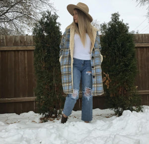 Model wearing women's tan and blue plaid faux fur lined jacket outdoors.