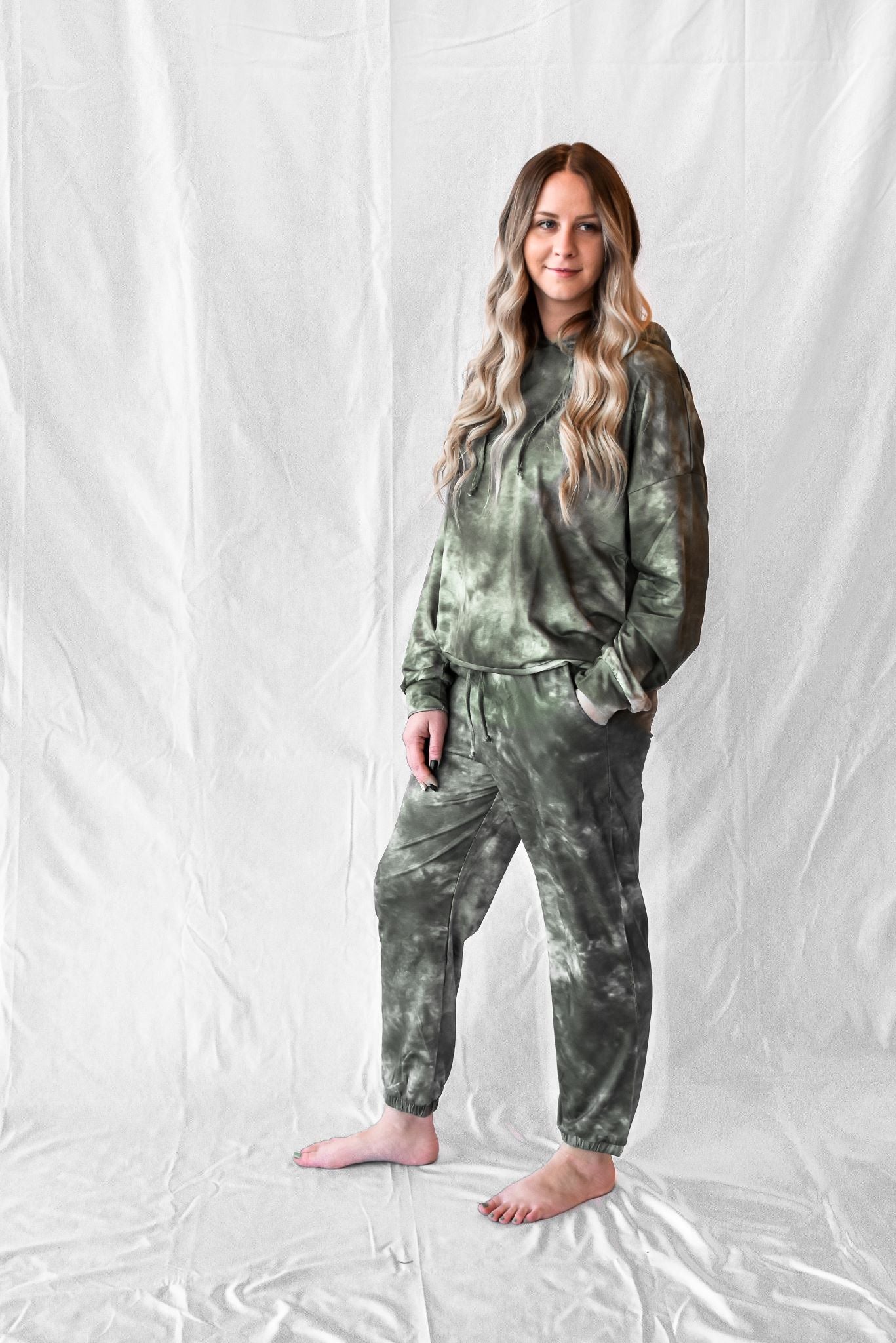 Model wearing women's green tie dye long sleeve hoodie and sweatpants loungewear set.