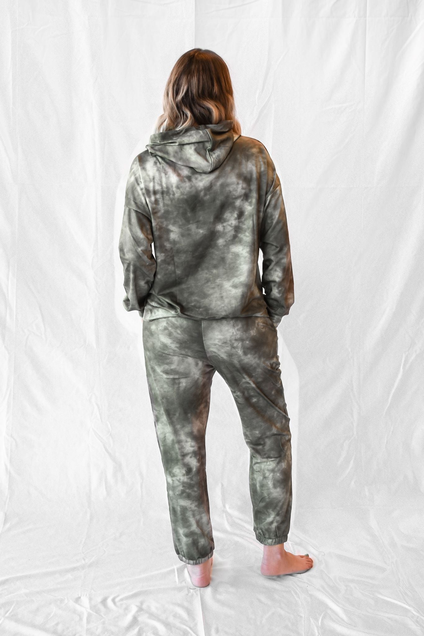 Model wearing women's green tie dye long sleeve hoodie and sweatpants loungewear set.