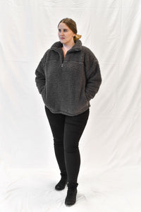 Model wearing women's grey sherpa half zip sweater with long sleeves.