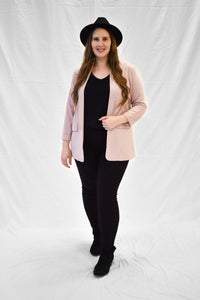 Model wearing light pink women's blazer with long sleeves.