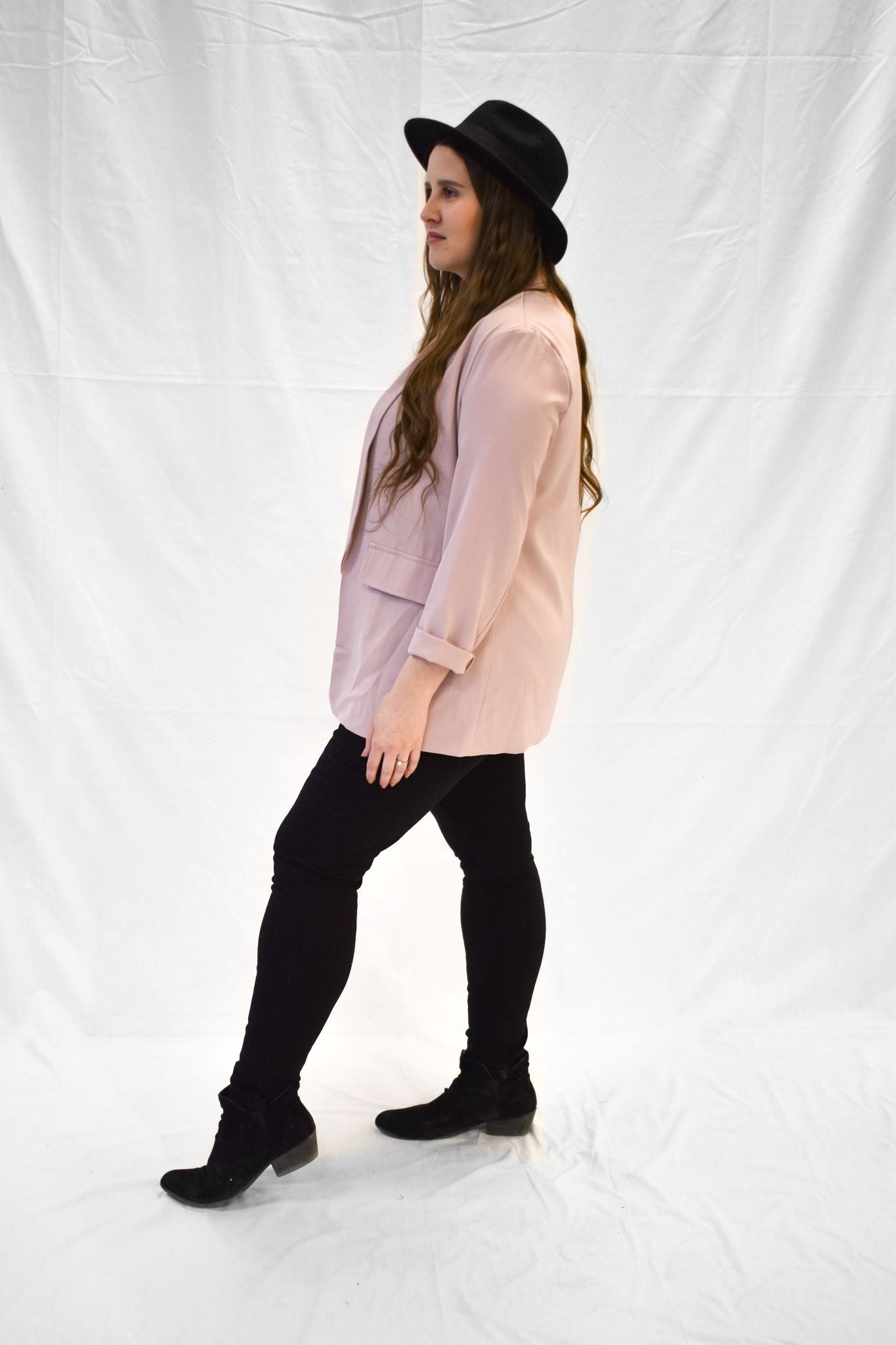 Model wearing light pink women's blazer with long sleeves.