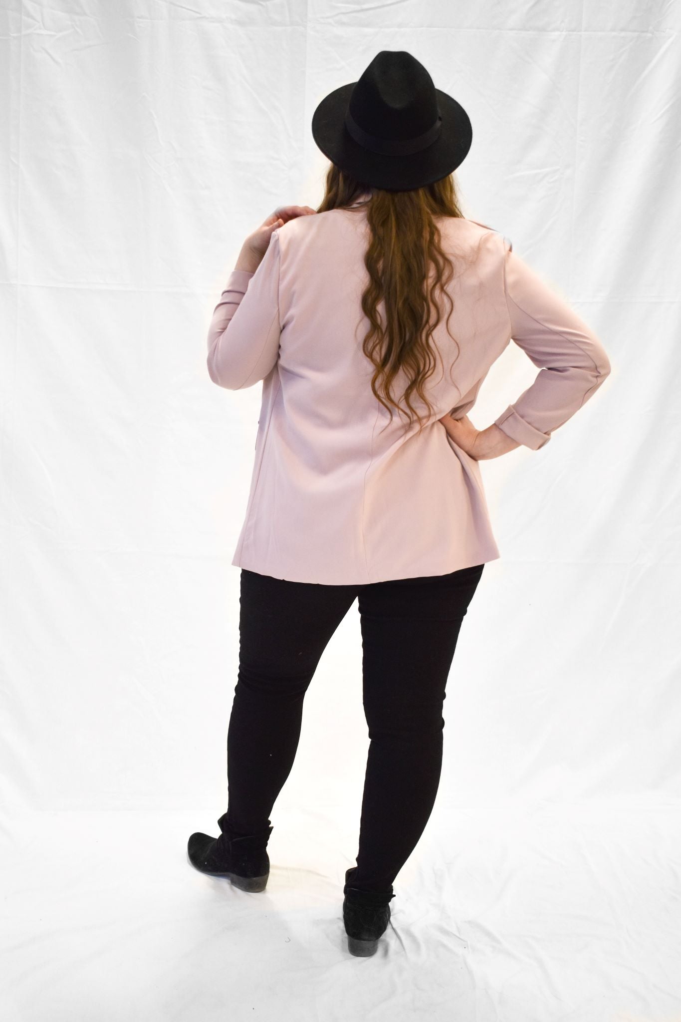 Model wearing light pink women's blazer with long sleeves.