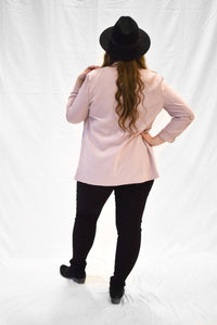 Model wearing light pink women's blazer with long sleeves.