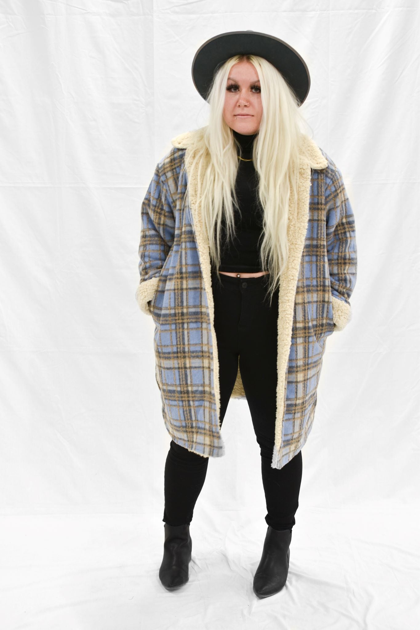 Model wearing women's tan and blue plaid faux fur lined jacket.