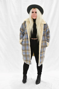 Model wearing women's tan and blue plaid faux fur lined jacket.