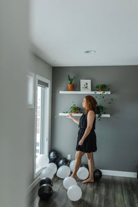 Model wearing women's little black sleeveless dress with ruffles.