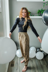 Model wearing women's black velvet ribbed mock neck cropped top with long sleeves.