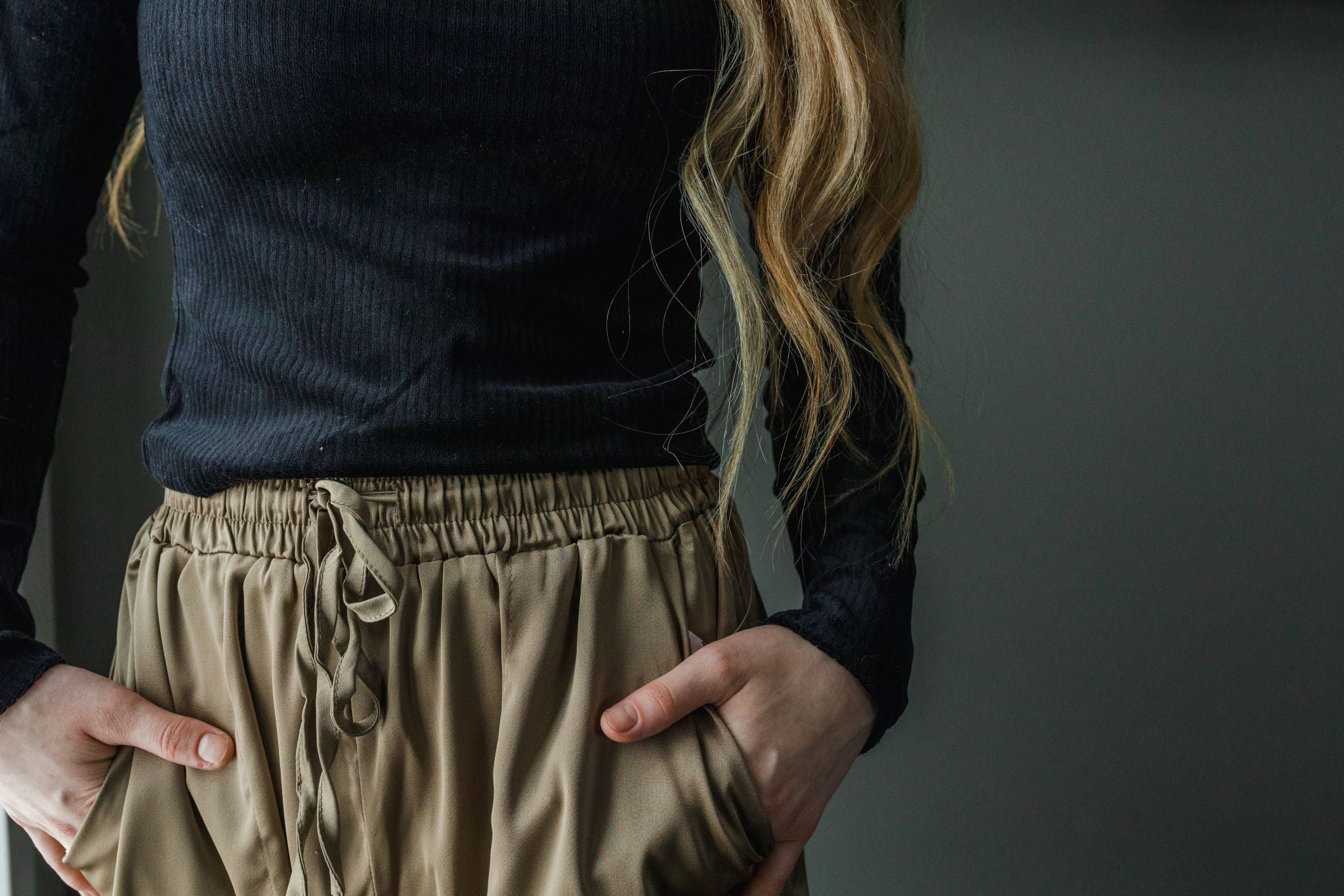 Close up of model wearing women's black velvet ribbed mock neck cropped top with long sleeves.