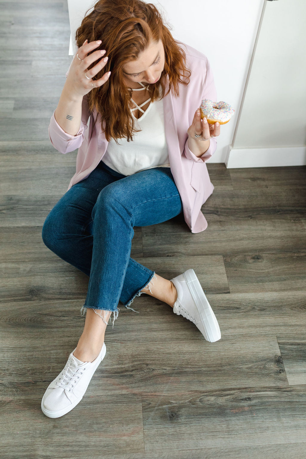 Model wearing a women's light pink blazer paired with jeans. 