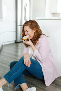 Model wearing a women's light pink blazer paired with jeans. 