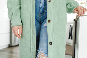 Close up of woman in sage green long fleece jacket.