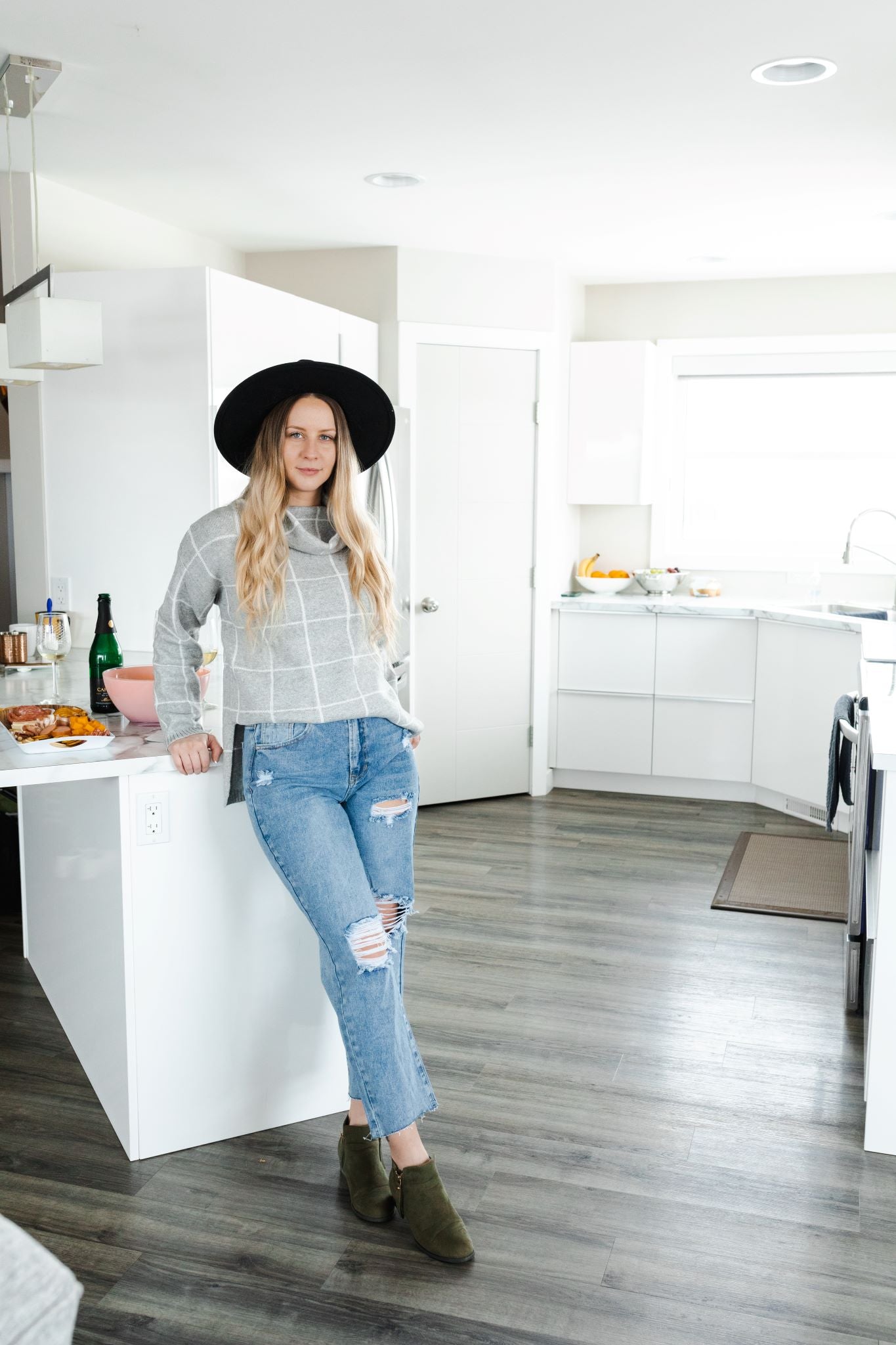 Model wearing women's light wash high waisted straight jeans with cropped bottoms.