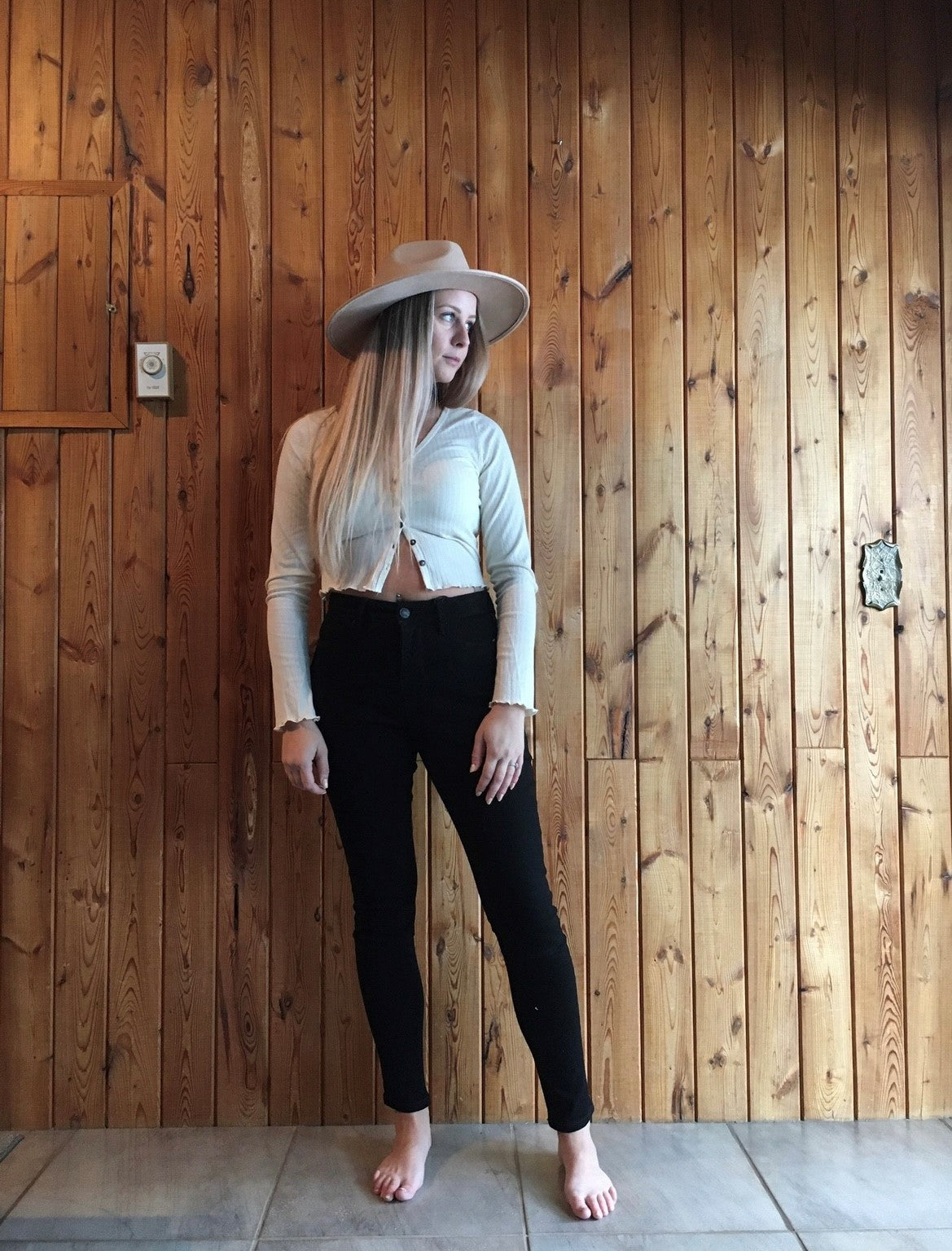 Model wearing women's cream coloured button up long sleeve cropped top.